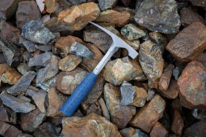 A geological hammer resting atop a pile of rocks.
